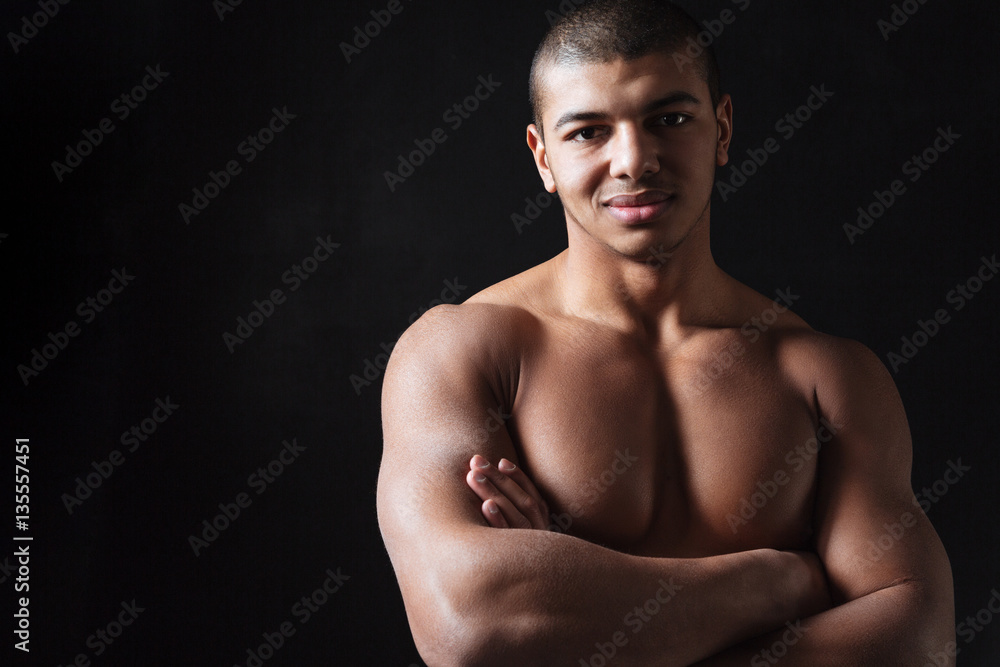 Fototapeta premium Cheerful young african sportsman standing with arms crossed