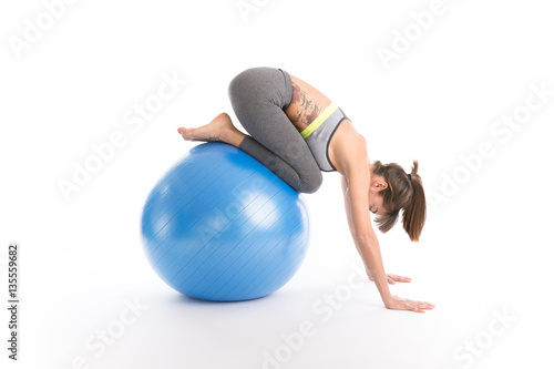 Beautiful fitness woman doing pilates exercises with fit ball. Isolated on white.