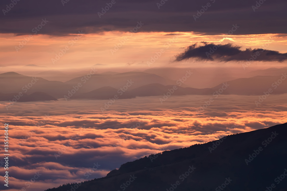 Sunrise in the mountains above the clouds