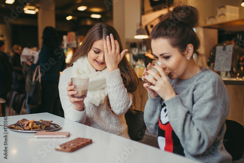 two girls driking coffee in cafe