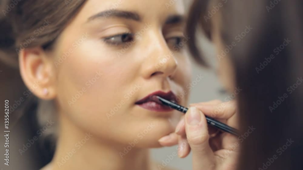 Applying cosmetics on lips of young woman. Panning Applying cosmetics on lips of young woman. Panning