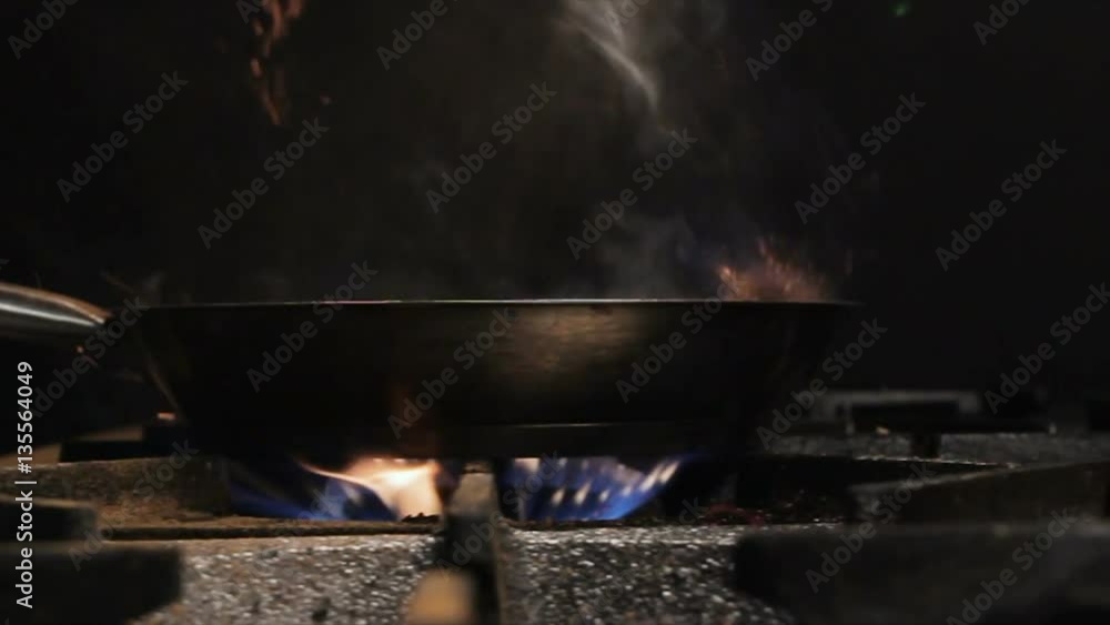 closeup open flame sparks with sparkles above gas stove due to run out cinnamon against dark kitchen. closeup open flame sparks with sparkles above gas stove due to run out cinnamon against dark kitchen.