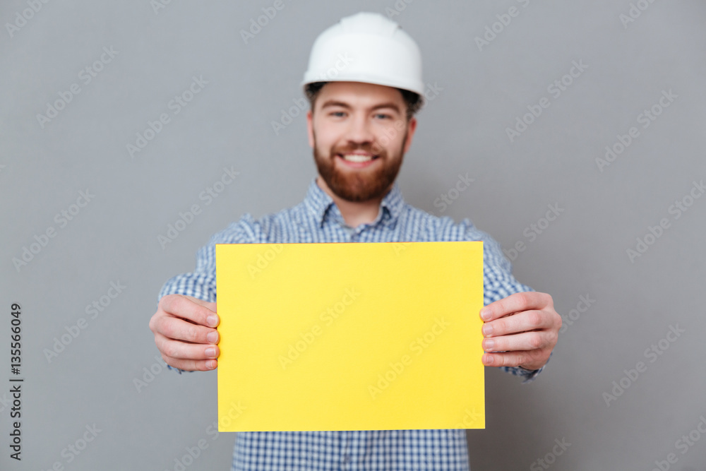 Bearded man builder showing copyspace blank to camera Bearded man builder showing copyspace blank to camera
