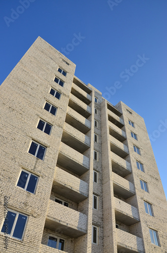 Photo of a newly built multi-storey building on a background of clear cloudless blue sky. Detailed photo of brick buildings with modern plastic windows photo