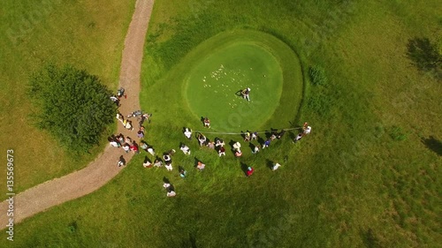 Aerial footage of a beautiful golf course with golfer making his putt