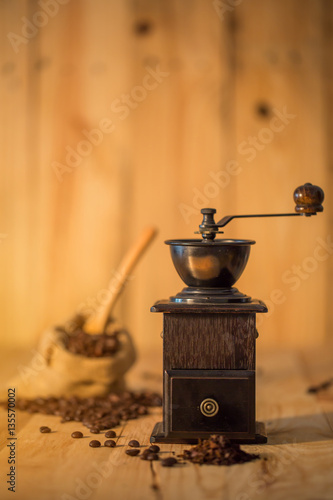 Manual coffee grinder and coffee bean on wooden surface