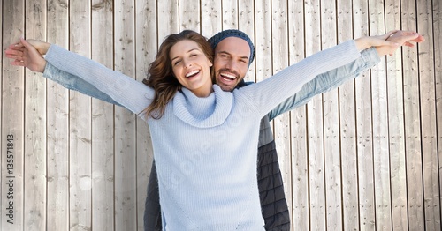 Portrait of happy couple standing with arms outstretched