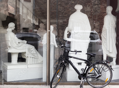 Tablou pe pânză Modern bike at ancient art museum's window