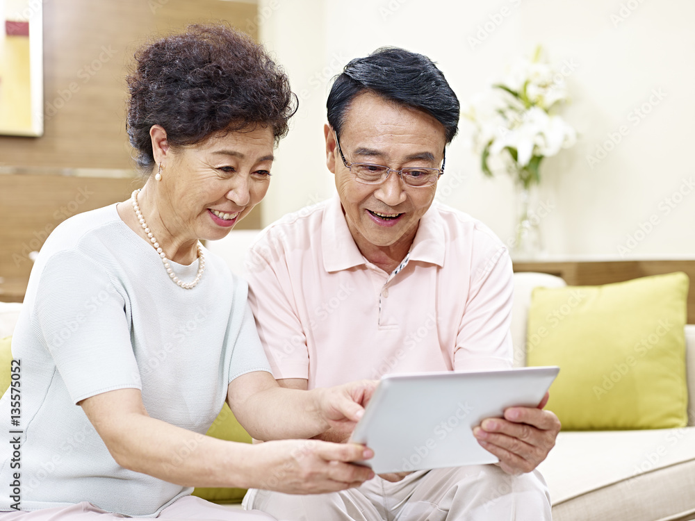 senior asian couple using tablet computer together