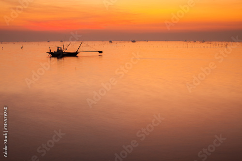 A colorful sky of sunset reflection on water and boat located at chonburi province of thailand