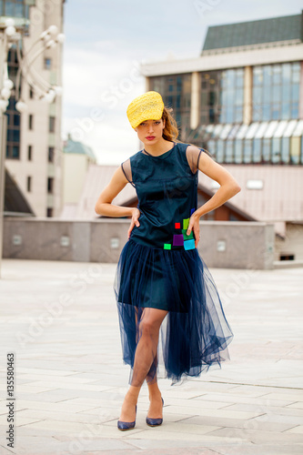 Portrait of a brunnete woman in yellow hat and blue dress photo