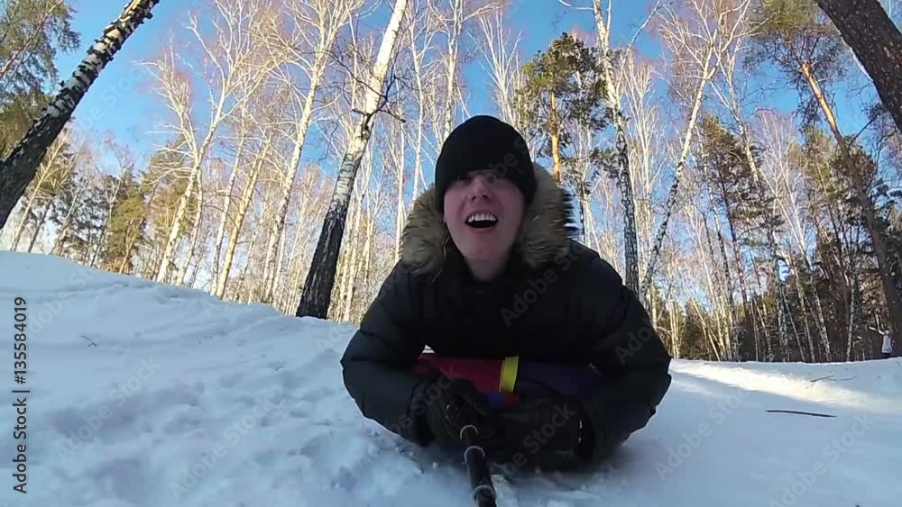 happy guy rides and smiling snowtube on snowy roads.slow motion. snow winter landscape. outdoors sports happy guy rides and smiling snowtube on snowy roads.slow motion. snow winter landscape. outdoors sports