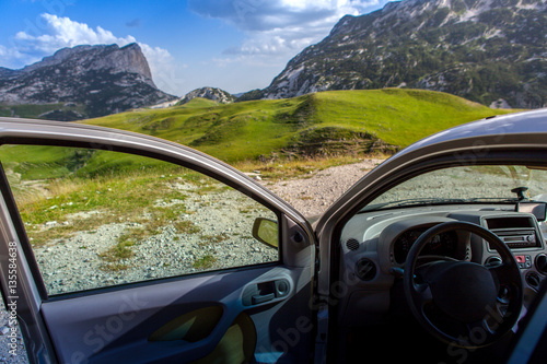 travel concept. the car with the door open on a background of mountains