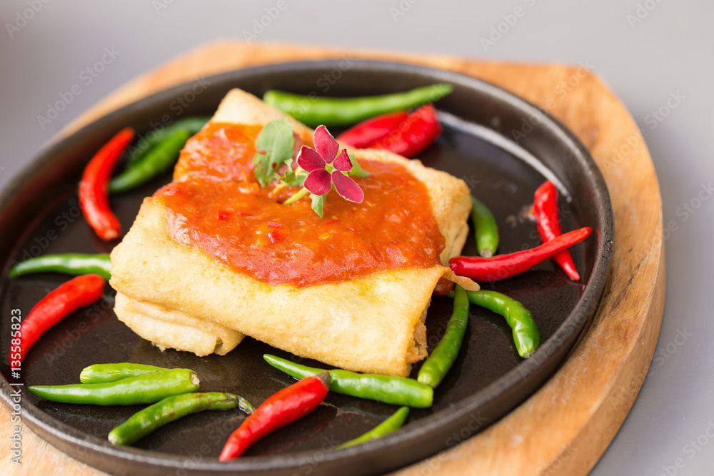 Hot plate tofu roll with spicy sauce on wooden table. Hot plate tofu roll with spicy sauce on wooden table.