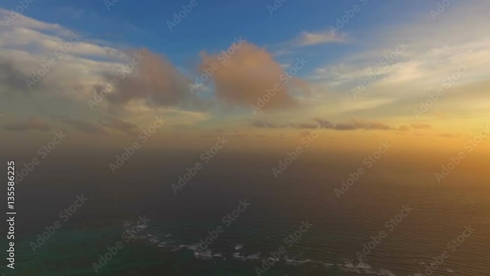 An incredible view of with quadrocopters the sky in the rays of the sunset and the ocean in the middle of the island