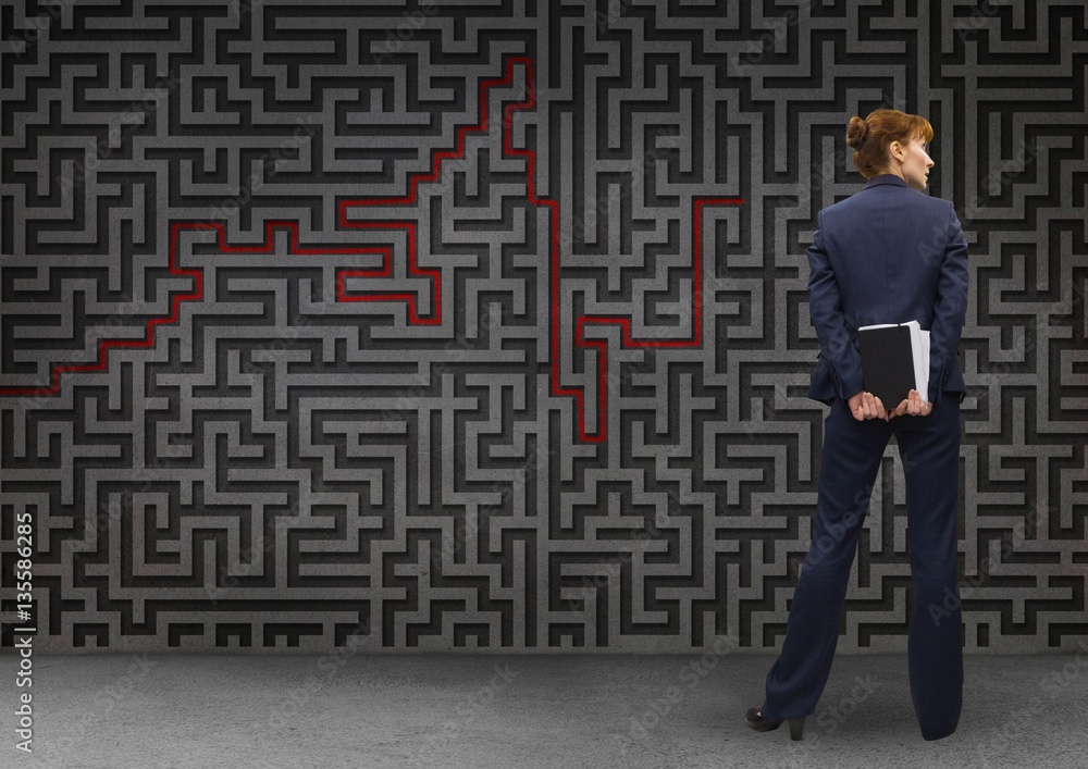 Businesswoman standing in front of maze Businesswoman standing in front of maze