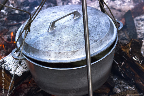 Cooking in cauldron on campfire at forest
