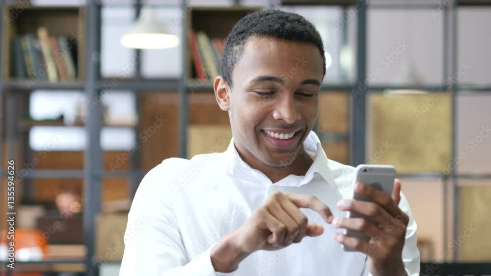 Black Man Using Smartphone in Office Black Man Using Smartphone in Office