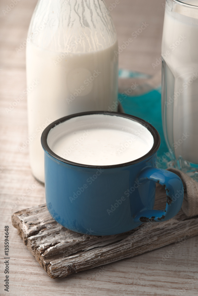 Glass, cup, bottle with kefir on a old stand Glass, cup, bottle with kefir on a old stand