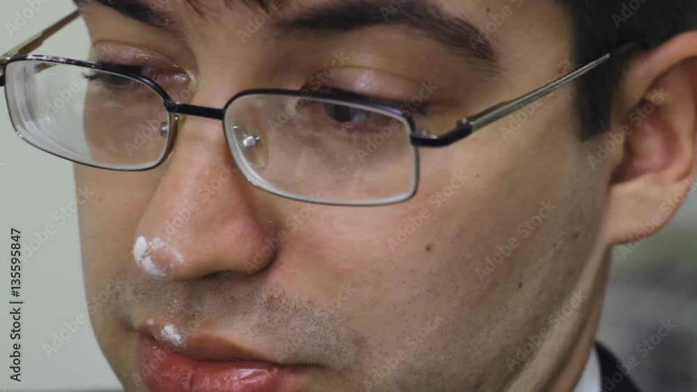 The man with the white powder on the nose twitches close-up The man with the white powder on the nose twitches close-up