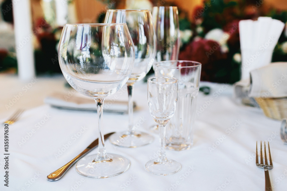 Glasses for water, vodka, wine and champagne stand by the knife