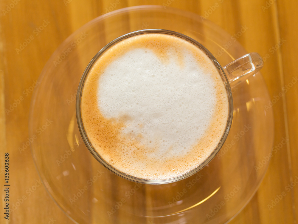 Golden bubble of hot coffee cup placed on a wooden table. Golden bubble of hot coffee cup placed on a wooden table.