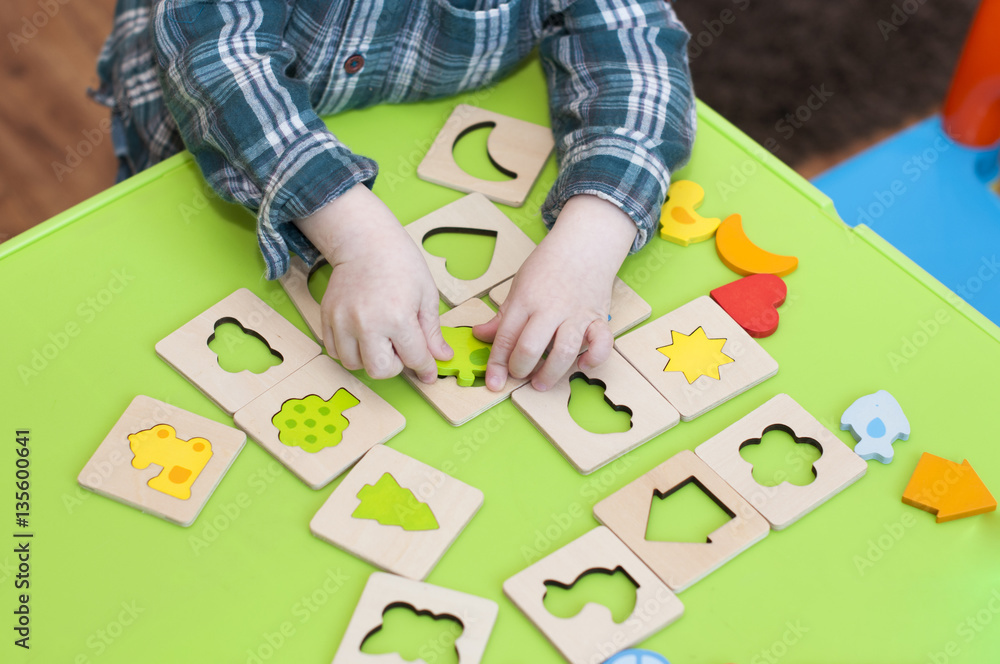 children's hands with a wooden sorter children's hands with a wooden sorter