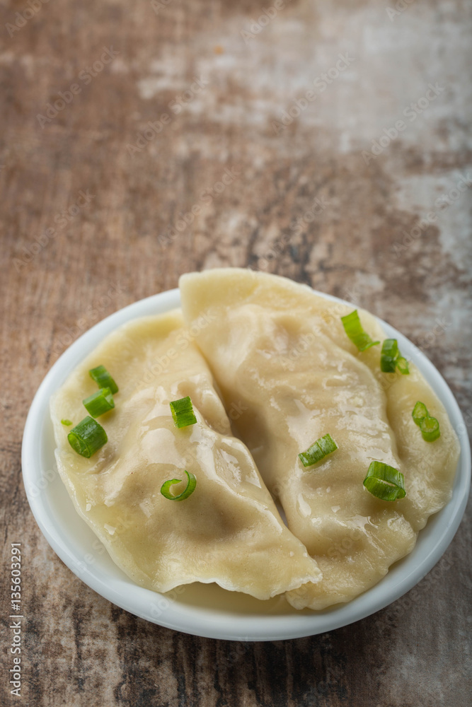 Two boiled dumplings with green onion. Rustic weathered wood background. Copy space Two boiled dumplings with green onion. Rustic weathered wood background. Copy space
