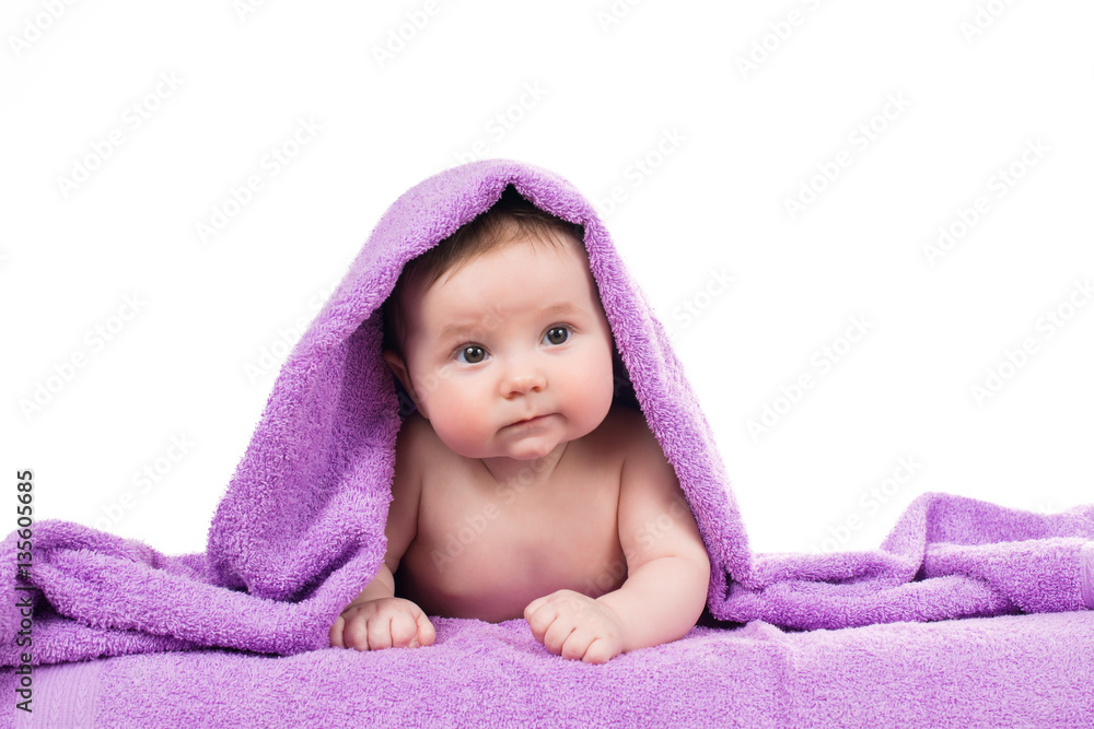Newborn baby lying down and smiling in a purple towel Newborn baby lying down and smiling in a purple towel