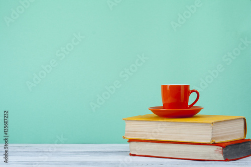 Stack of books on wooden tablle with a cup  tea. Education background. Back to school. Copy space for text. photo