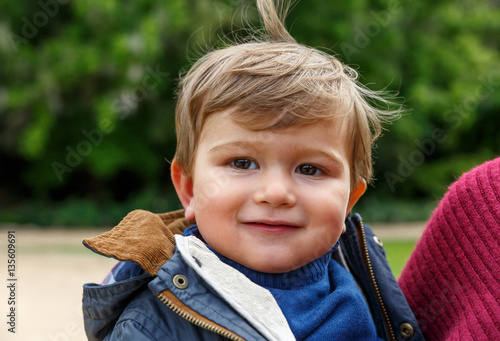 A cute child looks happy towards the front photo