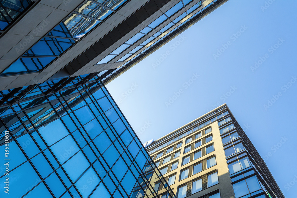 Fototapeta premium Modern architecture with glass facade under blue sky.