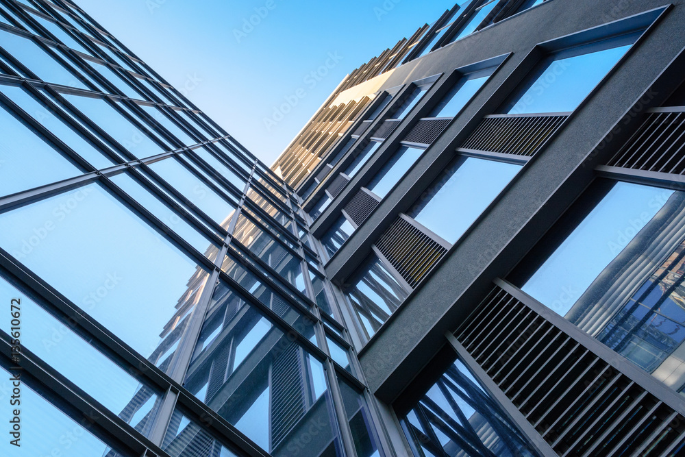 Modern architecture with glass facade under blue sky.