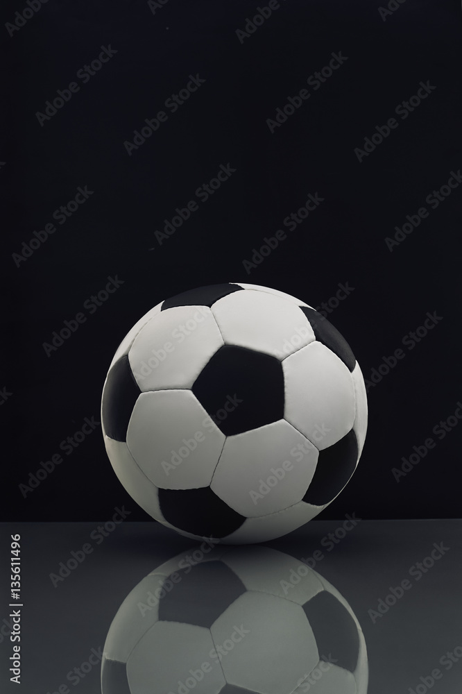 soccer ball with reflection on the table on a dark background