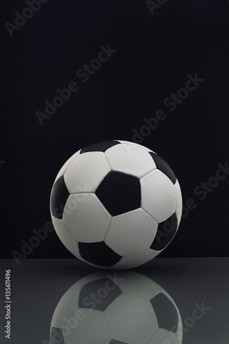 soccer ball with reflection on the table on a dark background