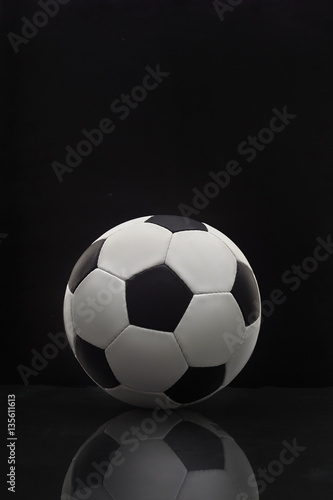 soccer ball with reflection on the table on a dark background