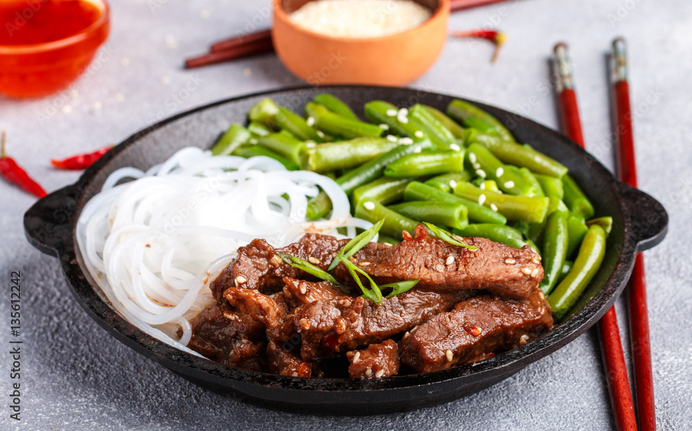 Fried spicy beef with sesame seeds, green beans and rice noodles. Dinner in the Asian style. Selective focus
Fried spicy beef with sesame seeds, green beans and rice noodles. Dinner in the Asian style. Selective focus