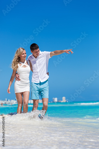 Romantic couple walking on beach and enjoying life