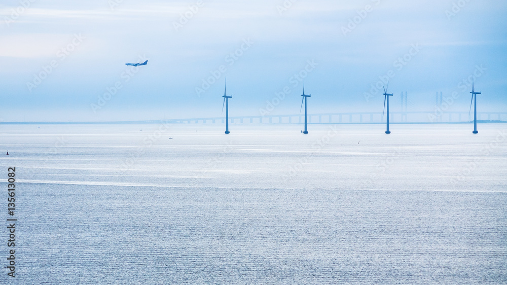 Obraz premium airplane, bridge and offshore wind farm in morning