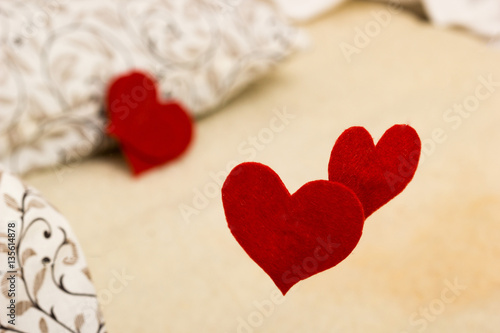 Small red heart from felt on linen