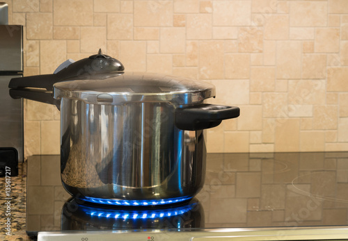 Foto Stainless steel pressure cooker on hob