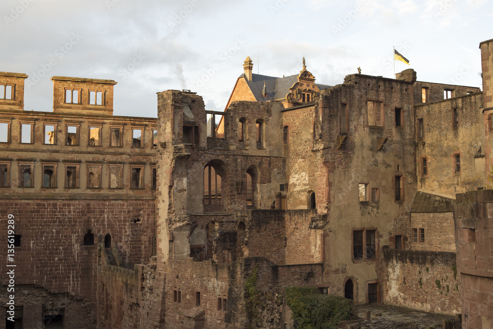 Old Heidelberg Castle or Heidelberger Schloss build in Middle Ages with German flag atop viewed inside before twilight