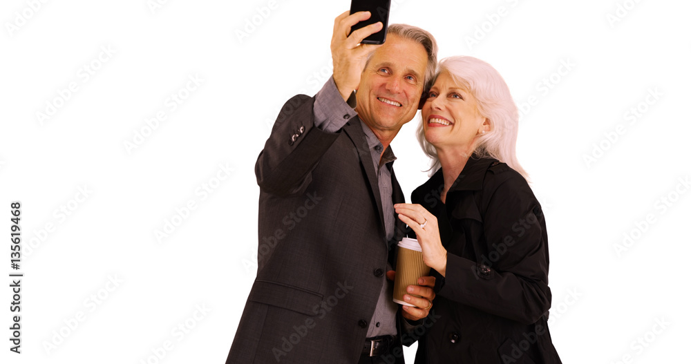 Elderly couple using smartphone to take pictures