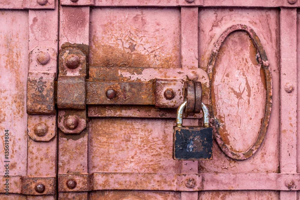 Lock with a latch on an old metal door in red Lock with a latch on an old metal door in red