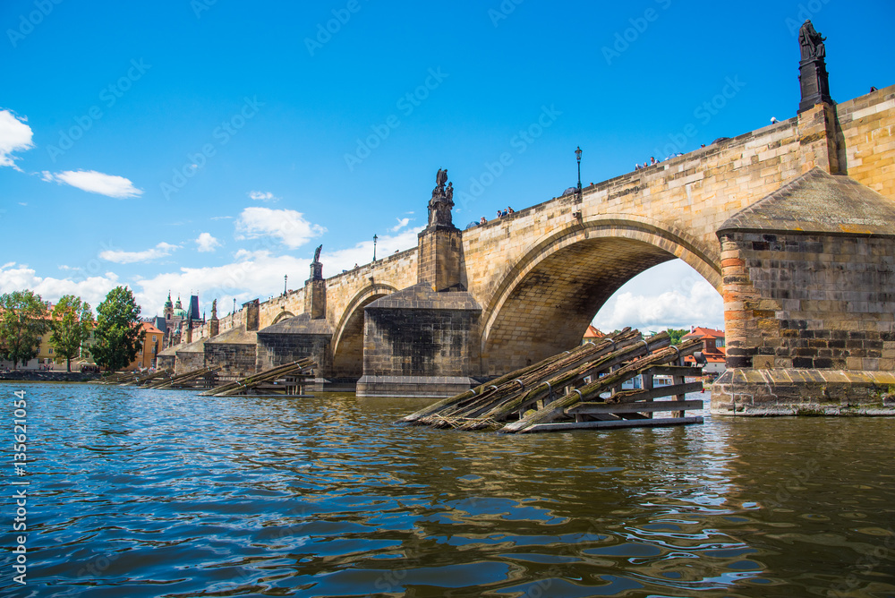Charles Bridge and Wooden icebreaker on the Vltava river in Prague