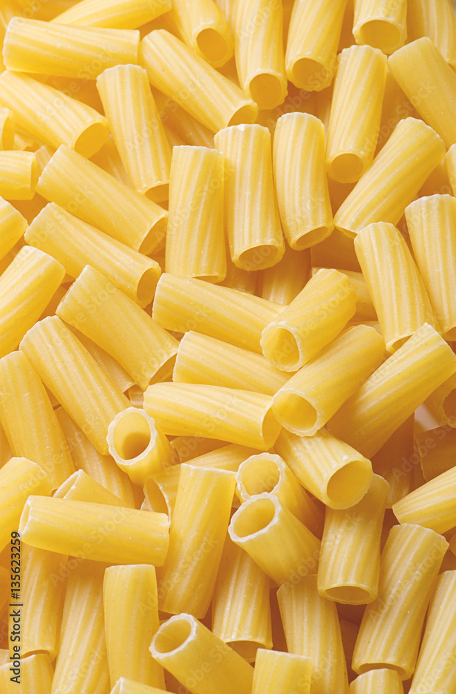 Background of tasty yellow macaroons. Vertical shoot of Italian pasta. Background of tasty yellow macaroons. Vertical shoot of Italian pasta.