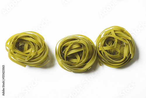 Res rolls of vegetable spaghetti on white background. Italian pasta. Horizontal shoot.