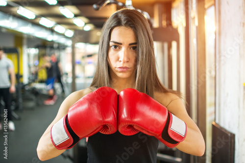 Young fitness girl with boxing gloves in gym. © Bojan