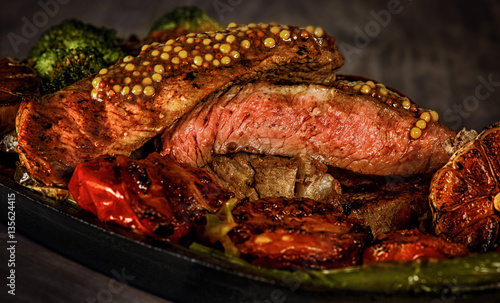 steak rare with the blood, pepper, garlic, tomatoes, broccoli, roasted on the grill, in a frying pan at home