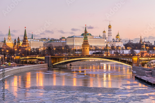 Illuminated Moscow Kremlin and Moscow river in winter morning. Pinkish and golden sky with clouds. Russia